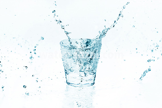 青色に着色されたロックグラスと水が散布する写真・フォト素材