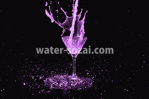 カクテルグラスの上で紫色の液体が跳ねる写真・フォト素材