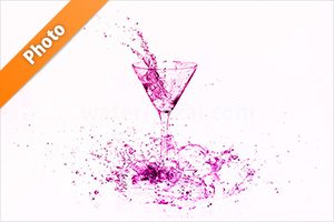 ピンク色に着色されたカクテルグラスと水が飛び散る写真・フォト素材
