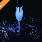 シャンパングラスと青い液体が飛び散る写真・フォト素材