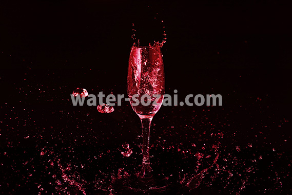 シャンパングラスと赤い液体が散布する写真・フォト素材