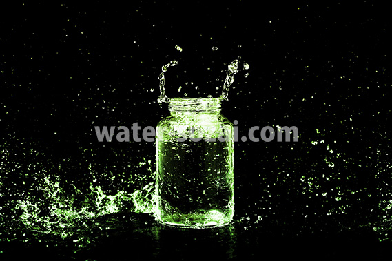 緑色に着色されたビンと水しぶきの写真・フォト素材