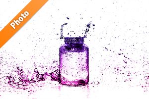 ピンク・紫色に着色されたビンと水しぶきの写真・フォト素材