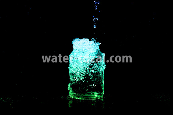 青・緑色に着色されたビンの水があふれる写真・フォト素材