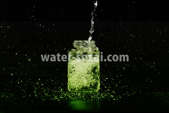 緑色に着色された、ビンに水が注がれる写真・フォト素材