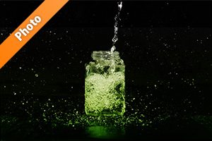 緑色に着色された、ビンに水が注がれる写真・フォト素材