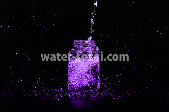 紫色に着色された、ビンに水が注がれる写真・フォト素材