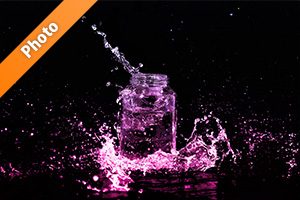 ピンクに着色されたビンと水が飛び散る写真・フォト素材