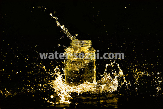 黄色に着色されたビンと水が飛び散る写真・フォト素材