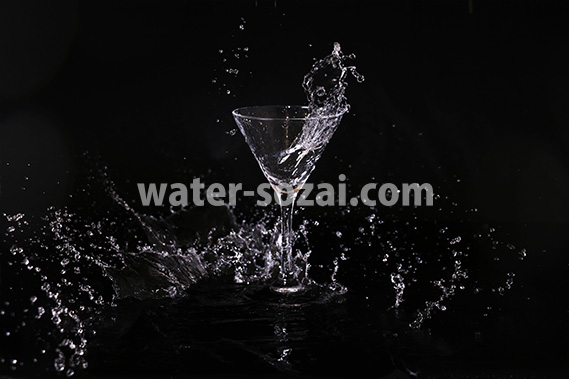 カクテルグラスの水が飛び散る写真・フォト素材