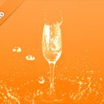 オレンジ色背景のシャンパングラスと水が飛び散る写真・フォト素材