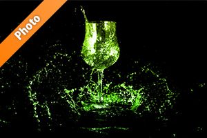 緑に着色されたワイングラスと水が散布する写真・フォト素材