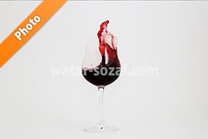 グラスの中で赤ワインが跳ねる写真・フォト