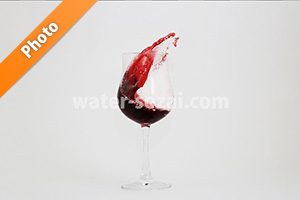 グラスと曲線を描く赤ワインの写真・フォト