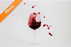 グラスと飛び散る赤ワインの写真・フォト