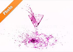 ピンク色に着色されたカクテルグラスと水が飛び散る写真・フォト素材