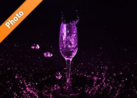 シャンパングラスとピンク・紫の液体が散布する写真・フォト素材