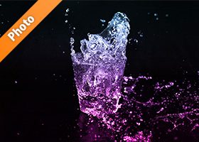 青からピンク色に着色されたロックグラスの水が弾ける写真・フォト