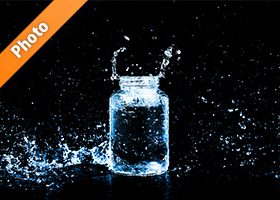 青色に着色されたビンと水しぶきの写真・フォト素材