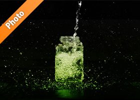 緑色に着色された、ビンに水が注がれる写真・フォト素材
