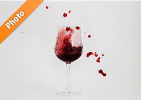 グラスと飛び散る赤ワインの写真・フォト